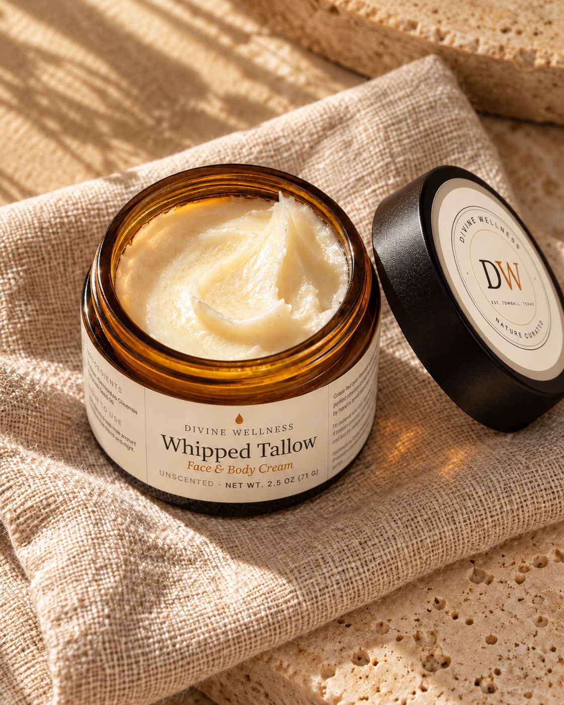 Open jar of whipped tallow face and body cream on soft linen